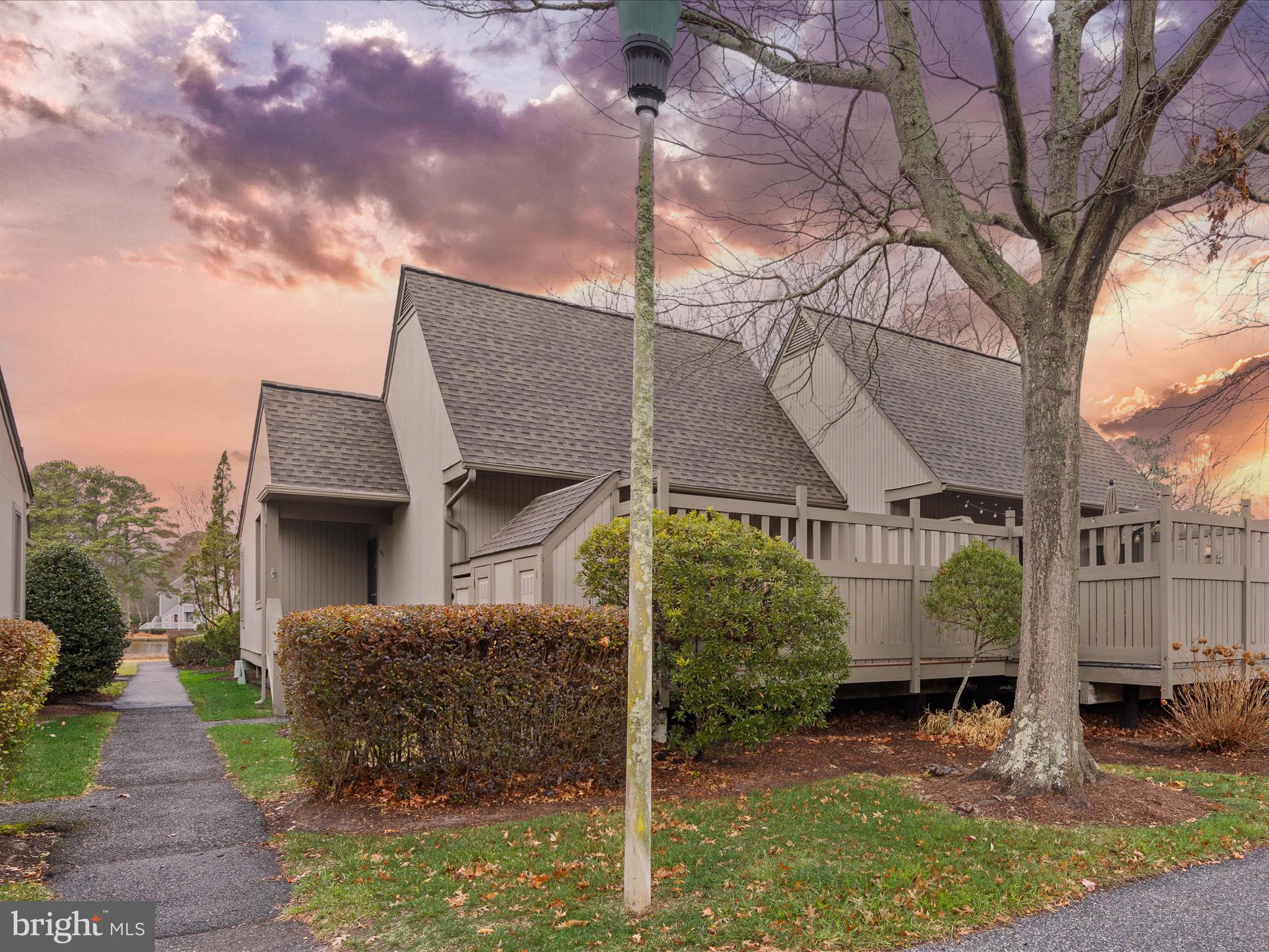 a view of a house with a yard and large tree