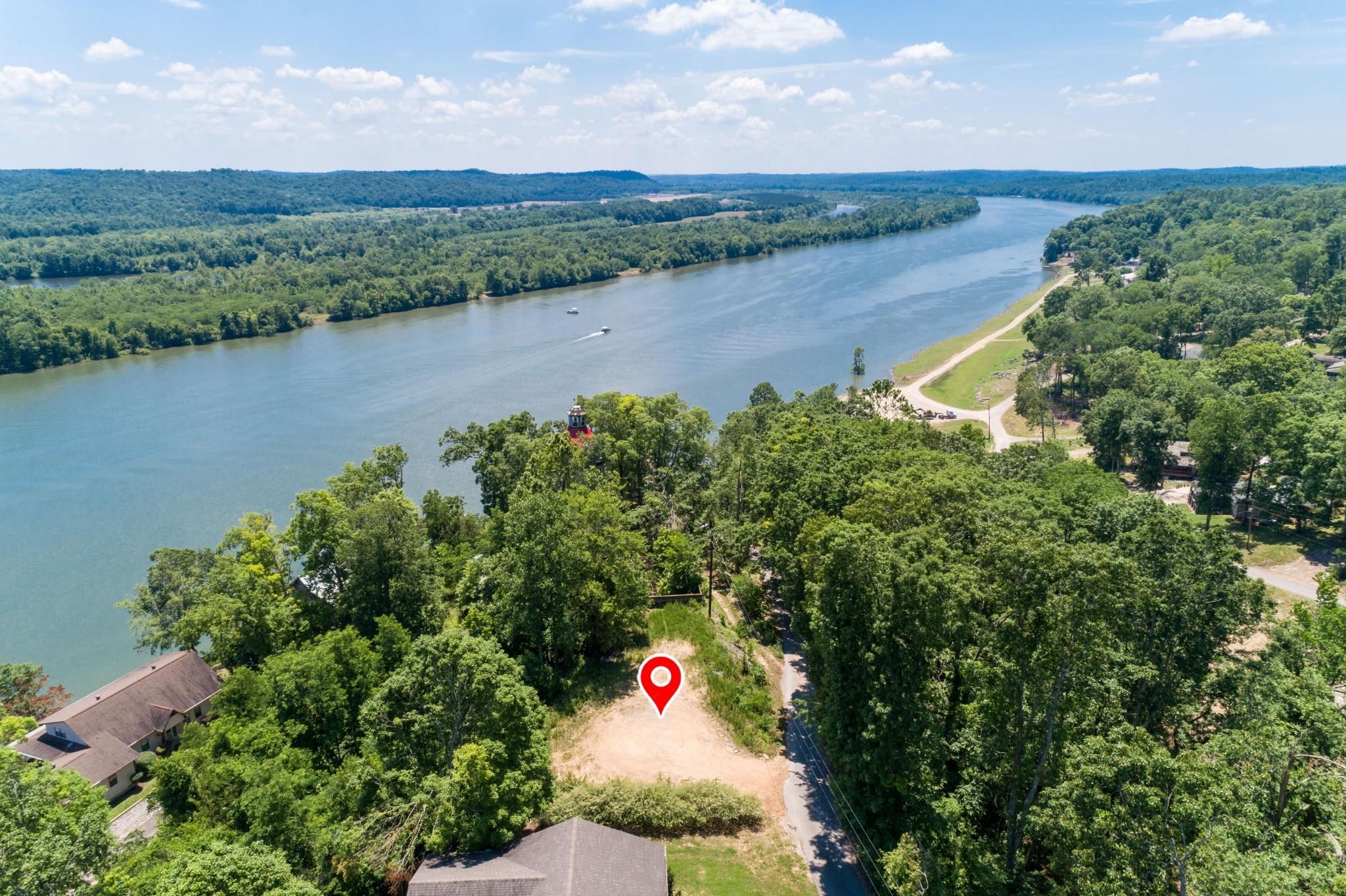 an aerial view of lake with residential house with outdoor space and trees around