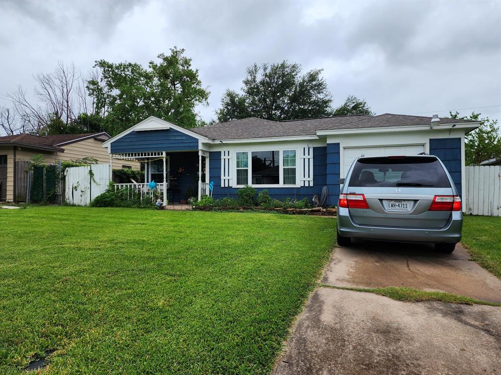 a car parked in front of a house with a yard