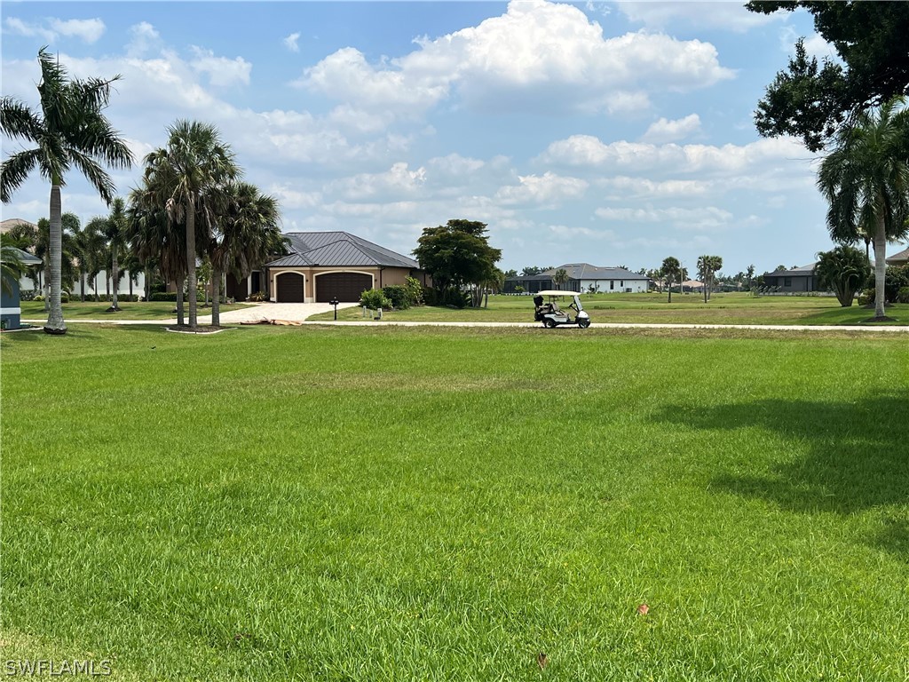 a view of a fountain in front of a house with a big yard