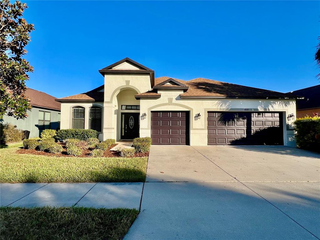 a front view of a house with a yard and outdoor seating