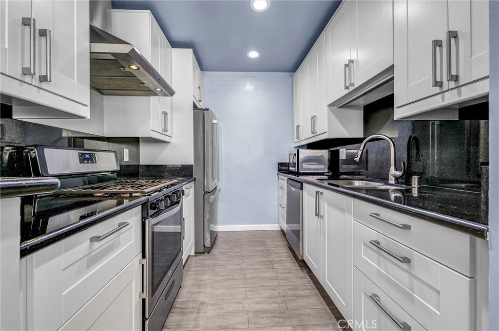 a kitchen with stainless steel appliances granite countertop a stove and a sink