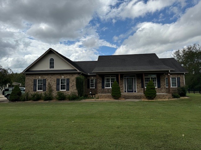 a front view of a house with a garden and trees