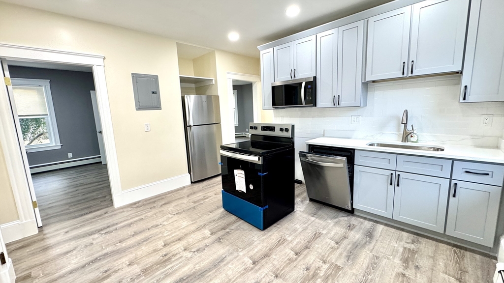 a kitchen with stainless steel appliances a stove a sink and a refrigerator