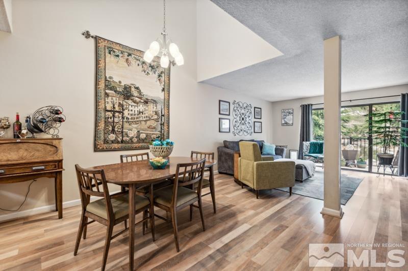 a dining room with furniture a chandelier and wooden floor