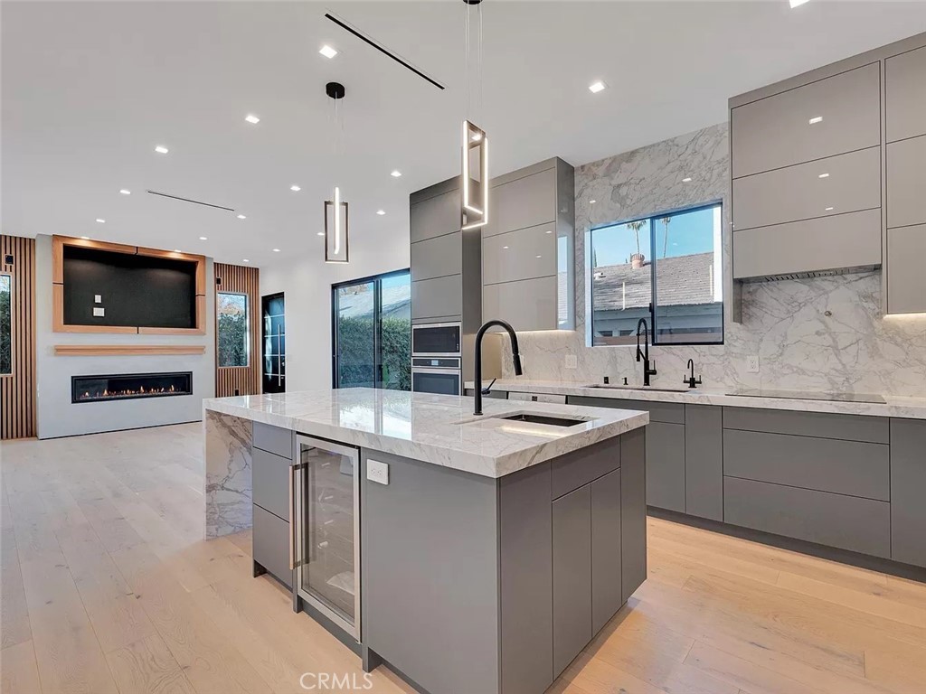 a kitchen with stainless steel appliances granite countertop a sink and a stove top oven with wooden floor