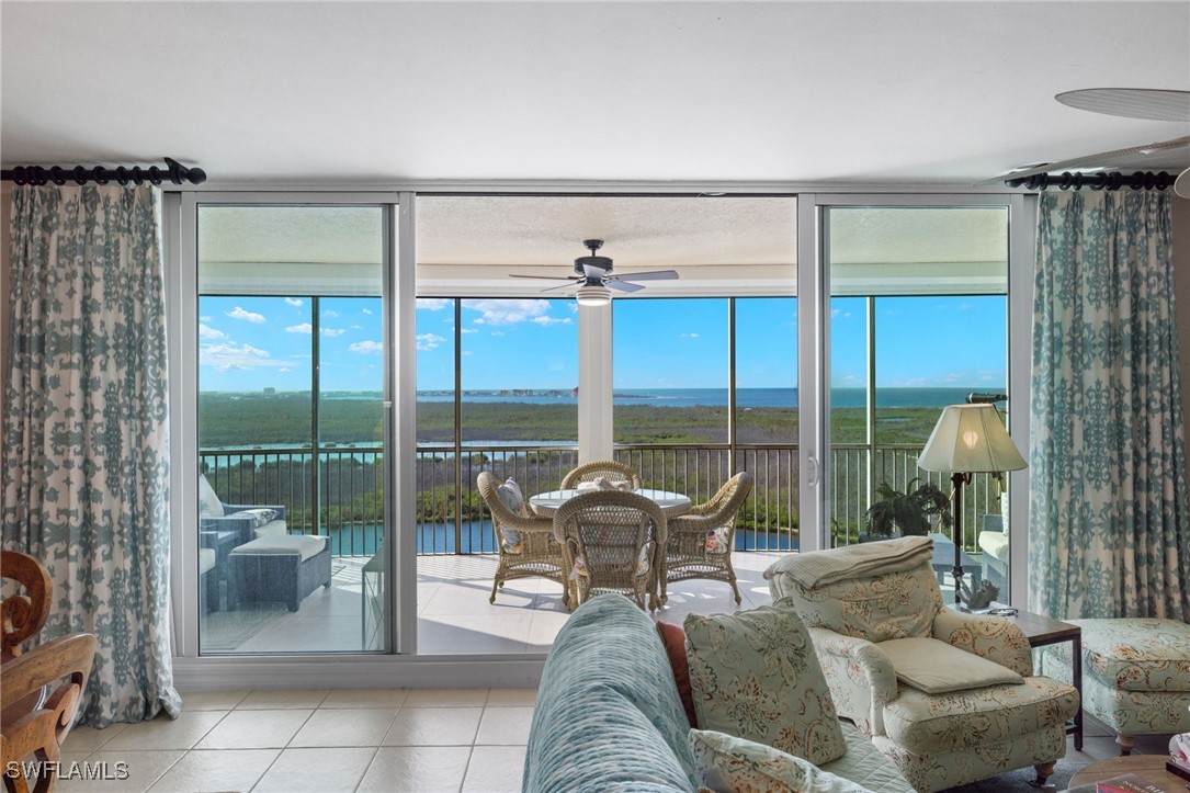 a living room with furniture and a floor to ceiling window