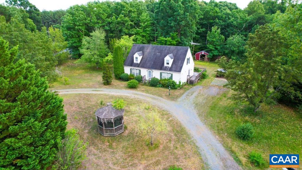 an aerial view of a house with garden space and a lake view