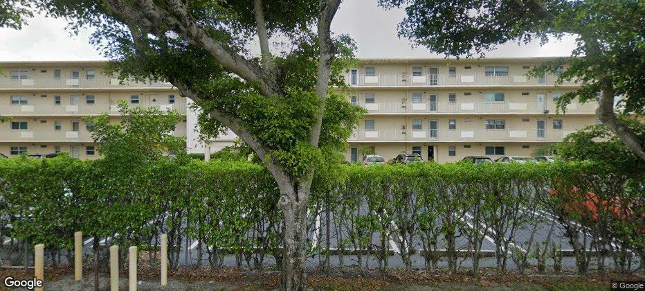 a front view of a residential apartment building with a yard