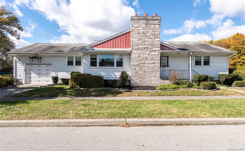 View of front facade with a garage and a front lawn