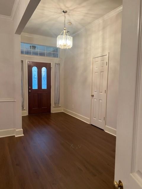 an empty room with wooden floor chandelier and windows