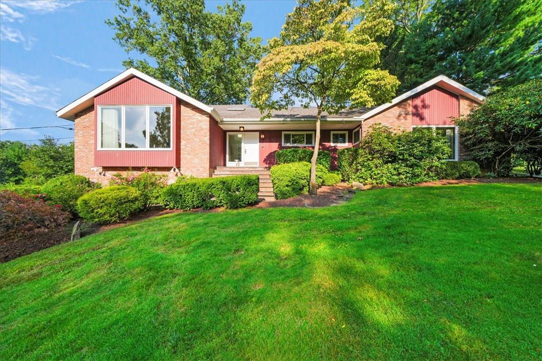 a front view of a house with a yard and potted plants