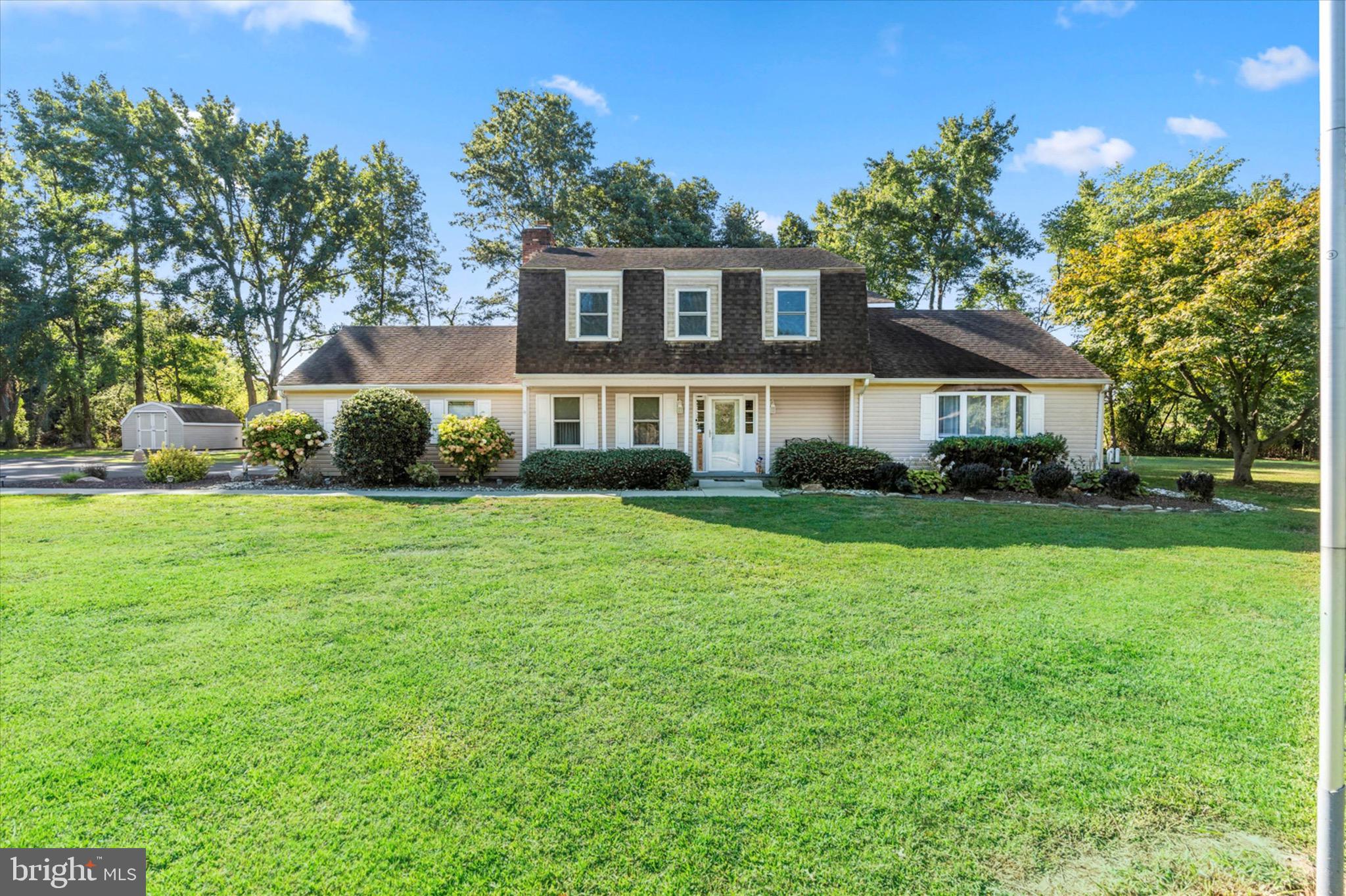 a front view of a house with a yard and trees