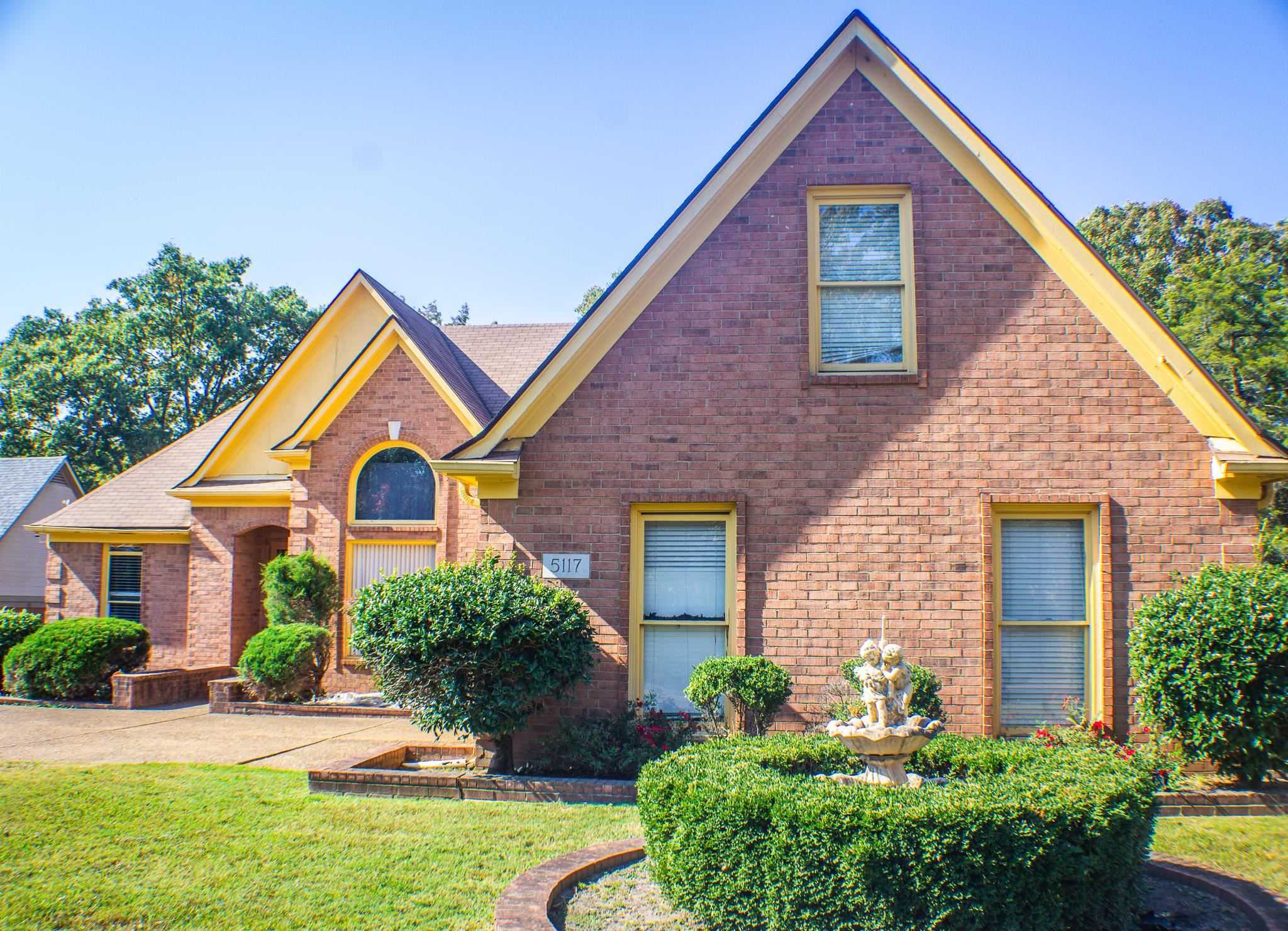 a front view of a house with yard and green space