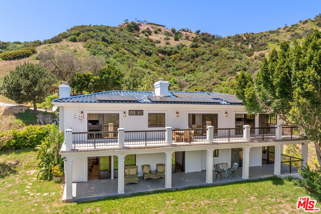 a view of a house with pool and chairs