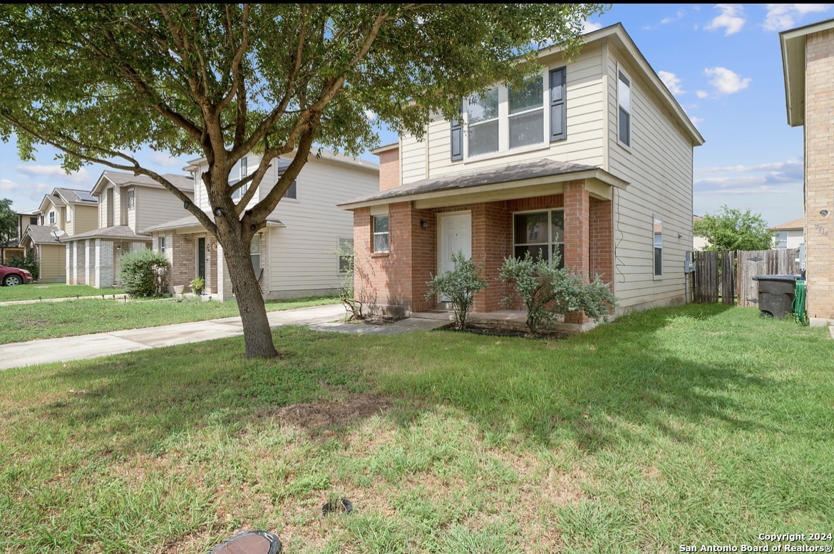 a view of a house with backyard and a tree