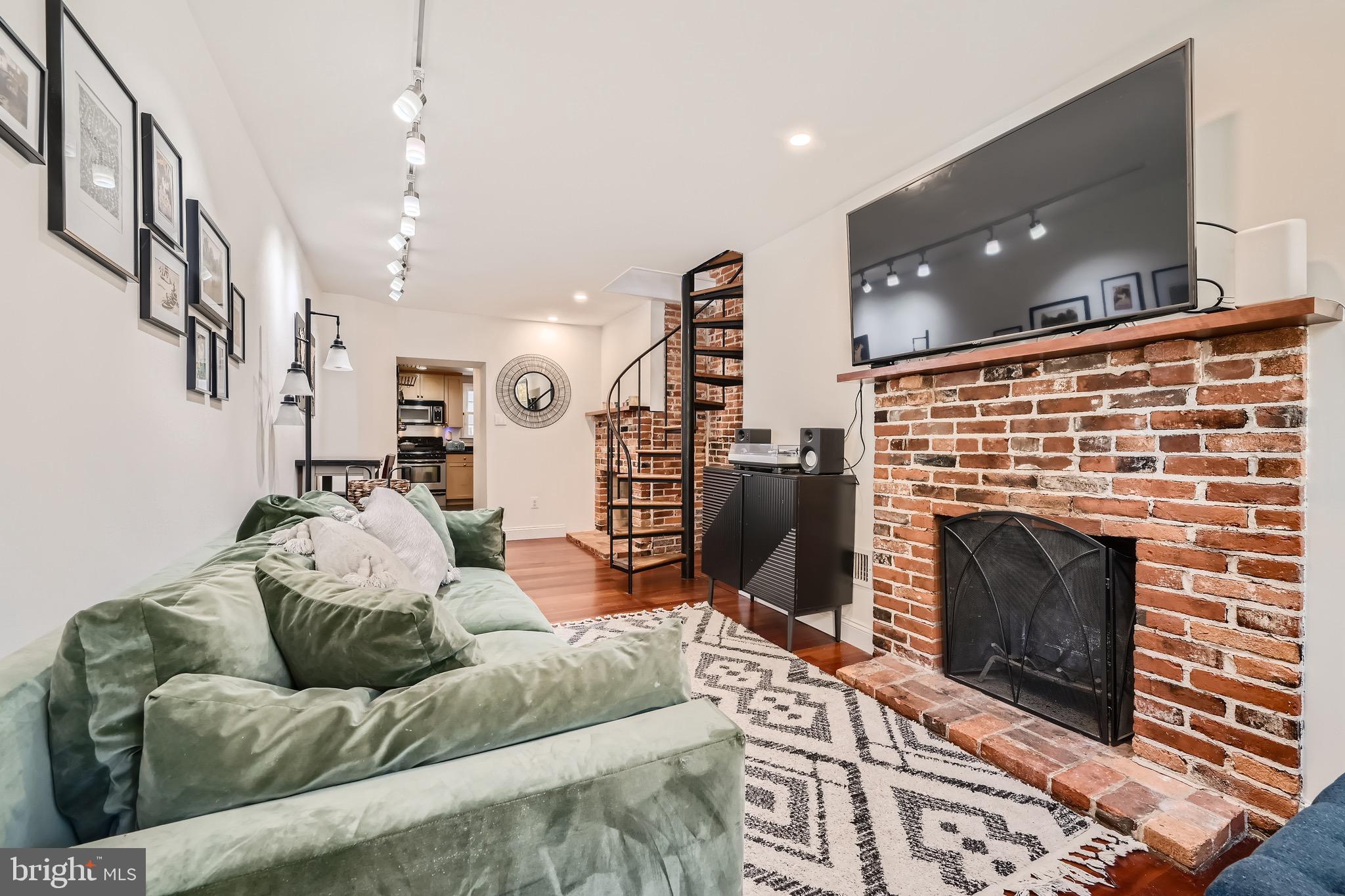 a living room with furniture a flat screen tv and a fireplace