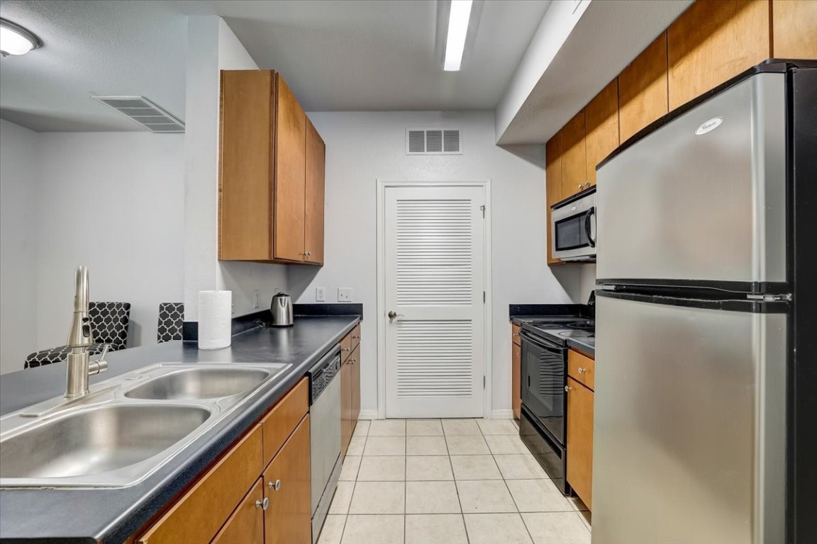 a kitchen with a sink a refrigerator and cabinets