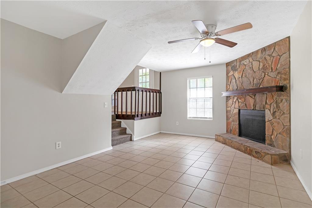 a view of an empty room with a fireplace and a window