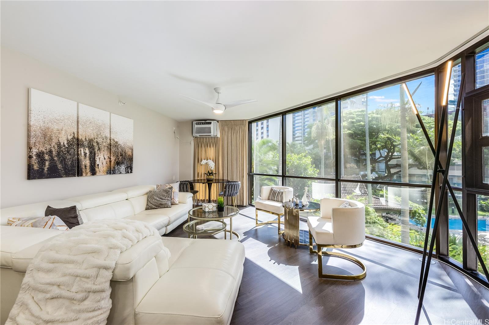 a living room with furniture large window and wooden floor