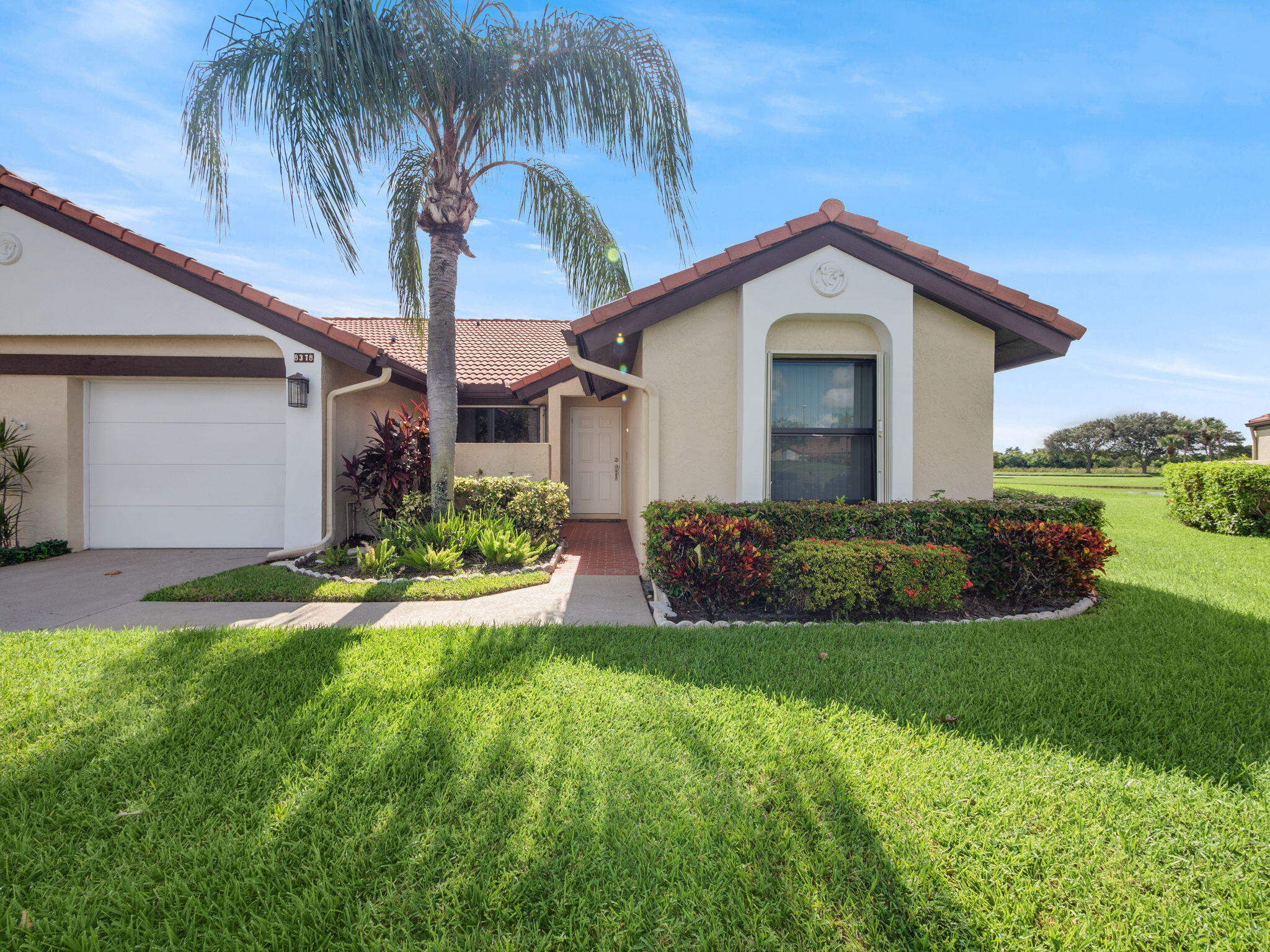 a view of a house with a yard and potted plants