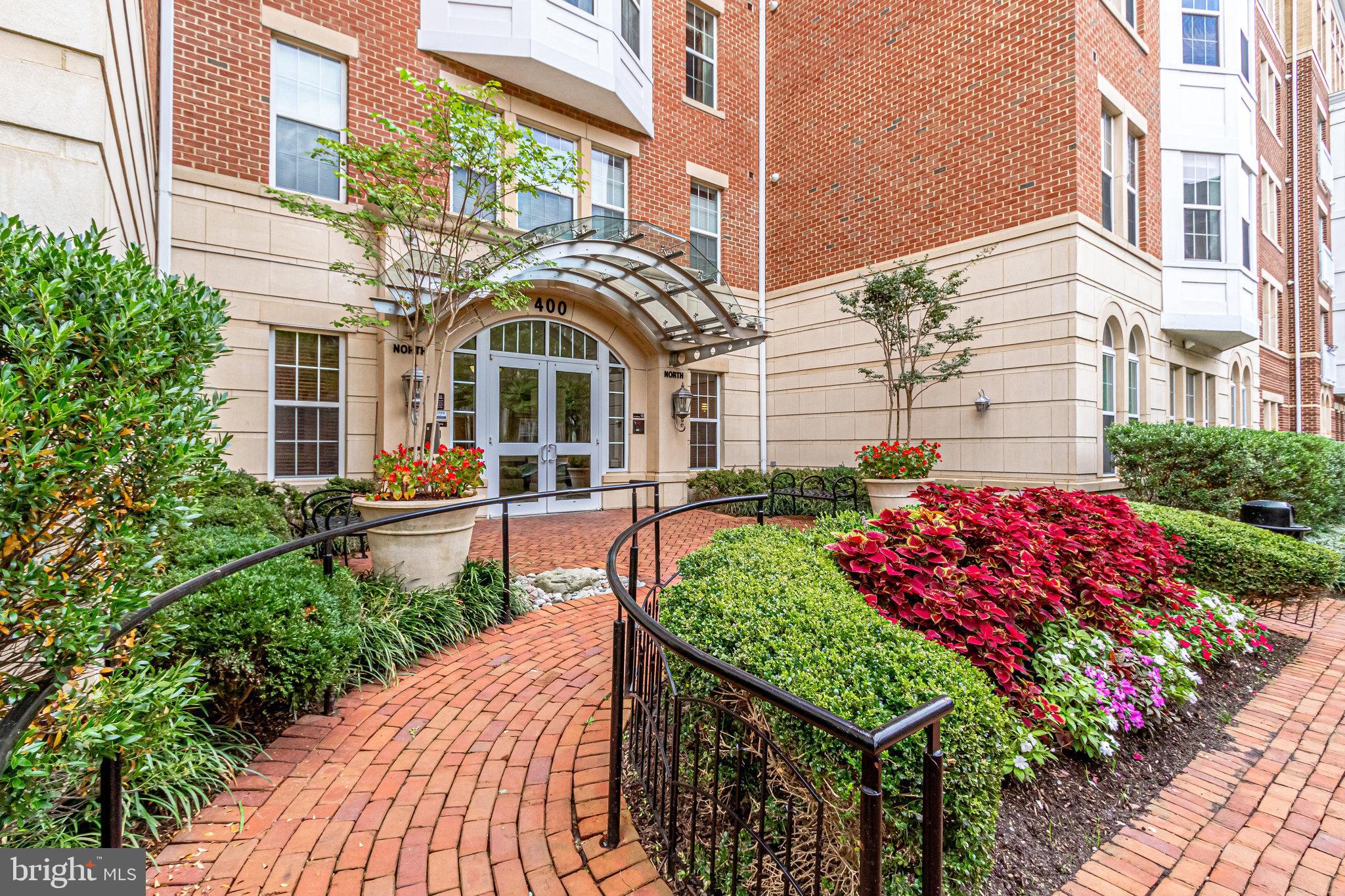 a front view of a multi story residential apartment building with yard