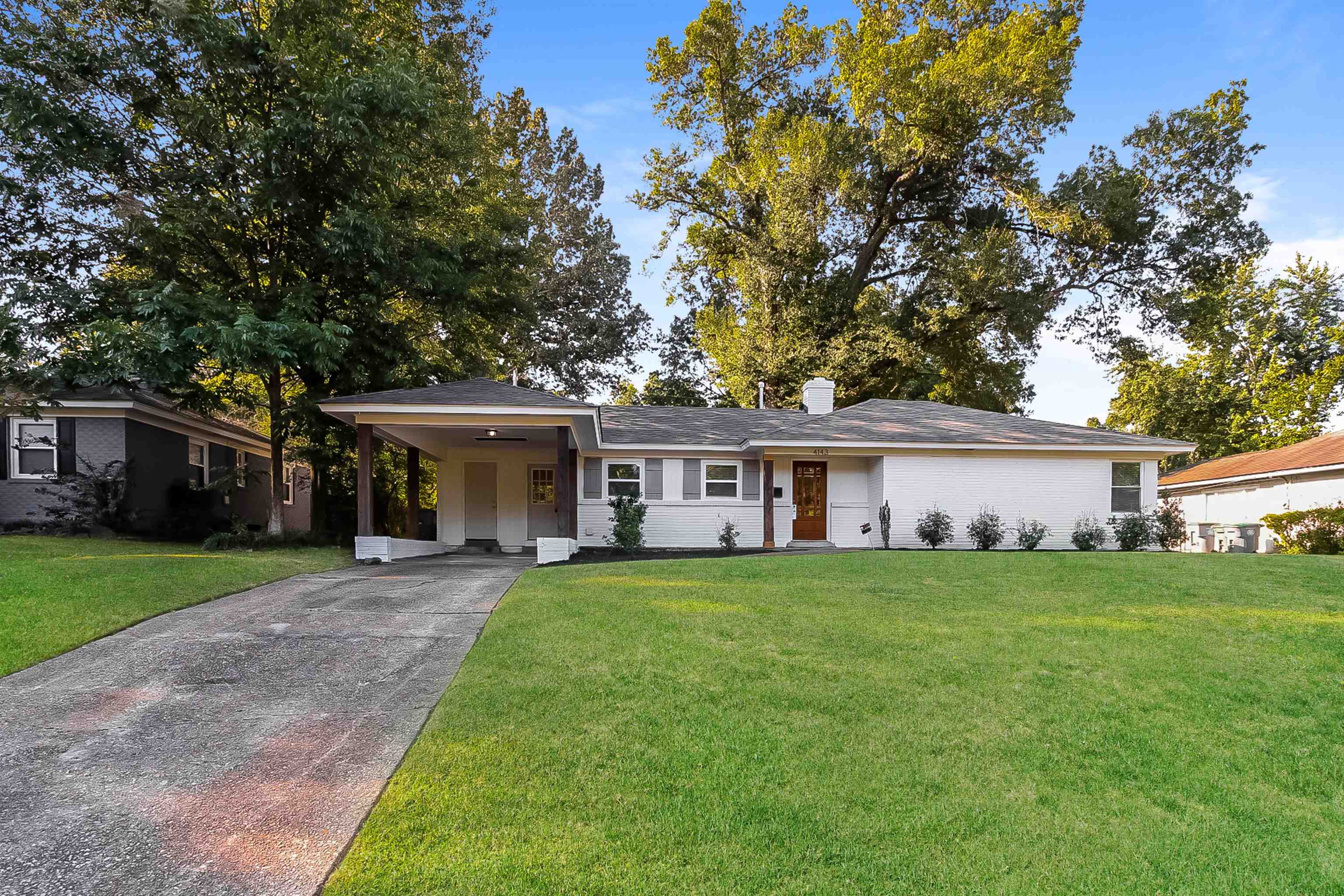 front view of a house and a yard and trees