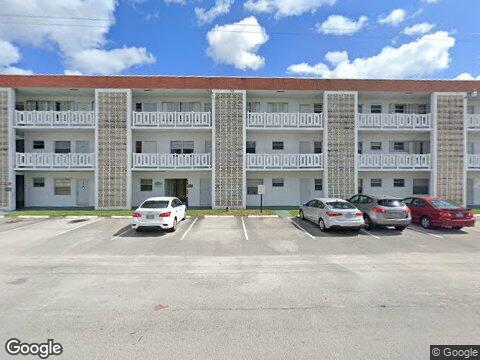 a view of building with cars parked in front of it