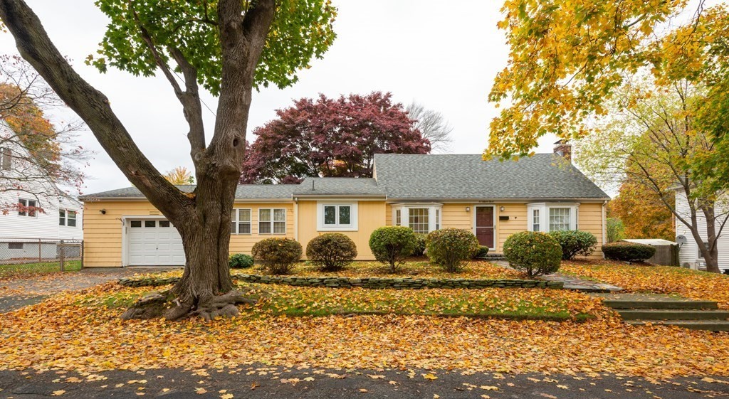 a front view of a house with a yard and trees