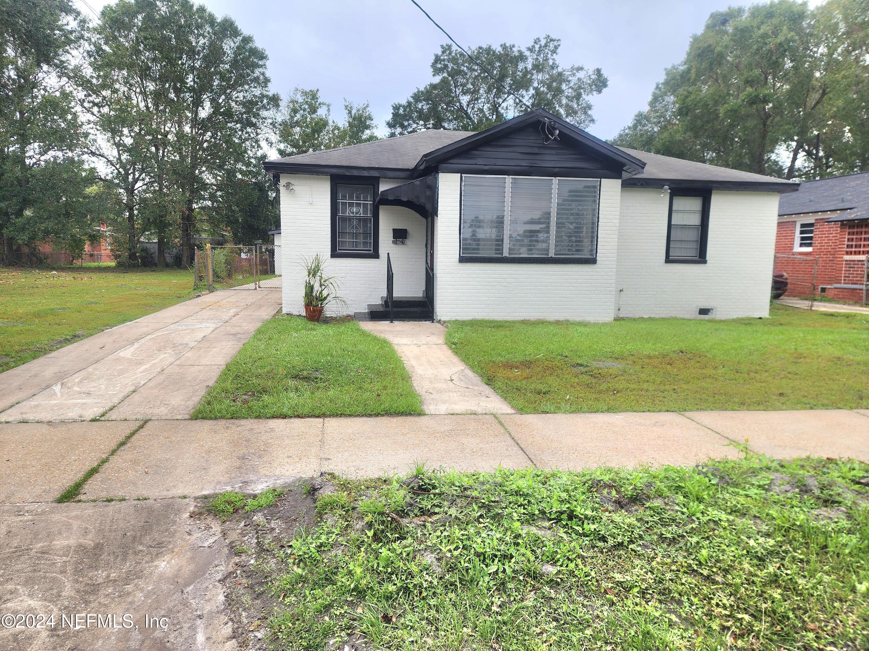 a front view of a house with a yard and trees