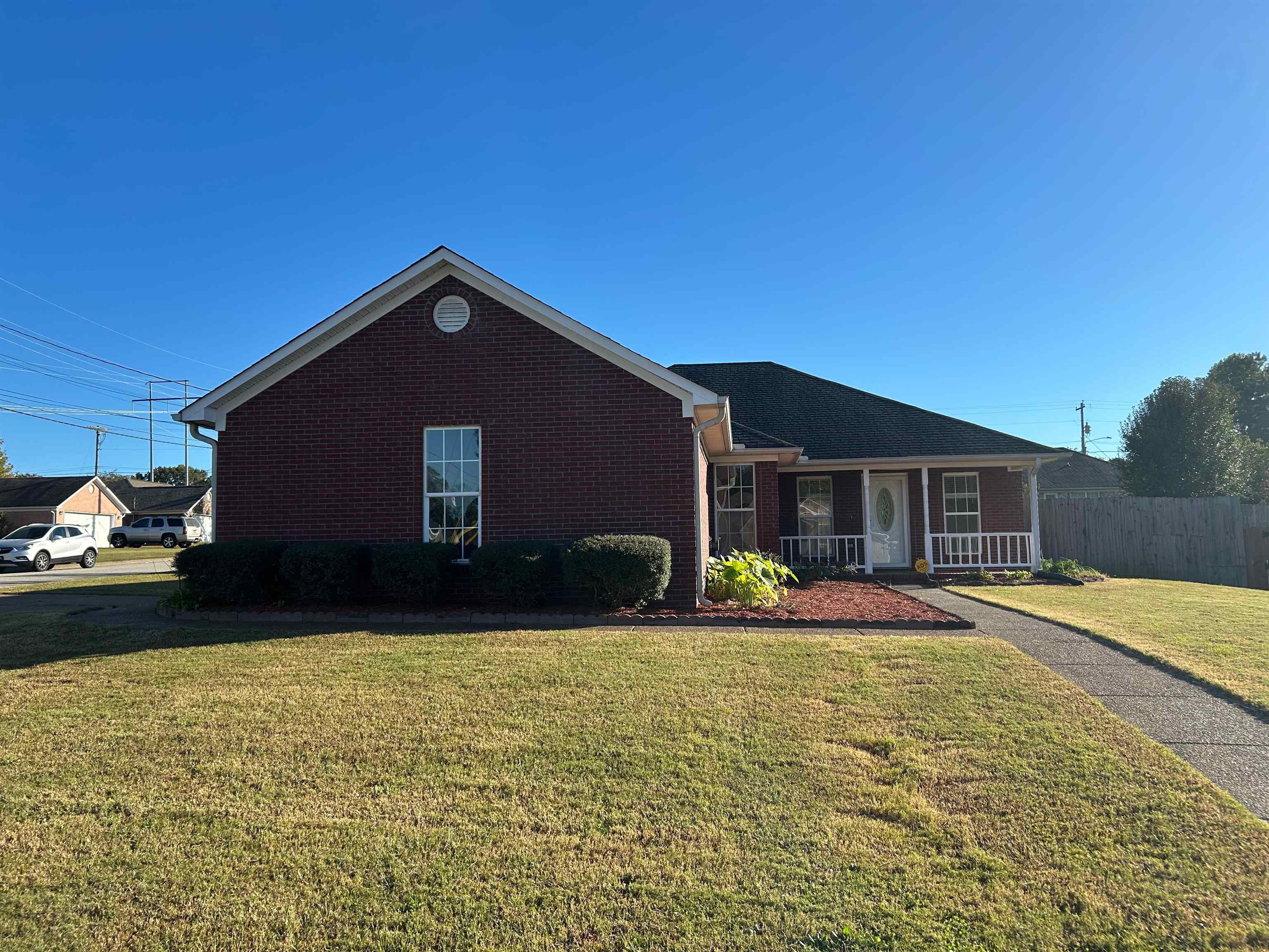 Ranch-style house featuring a porch and a front lawn