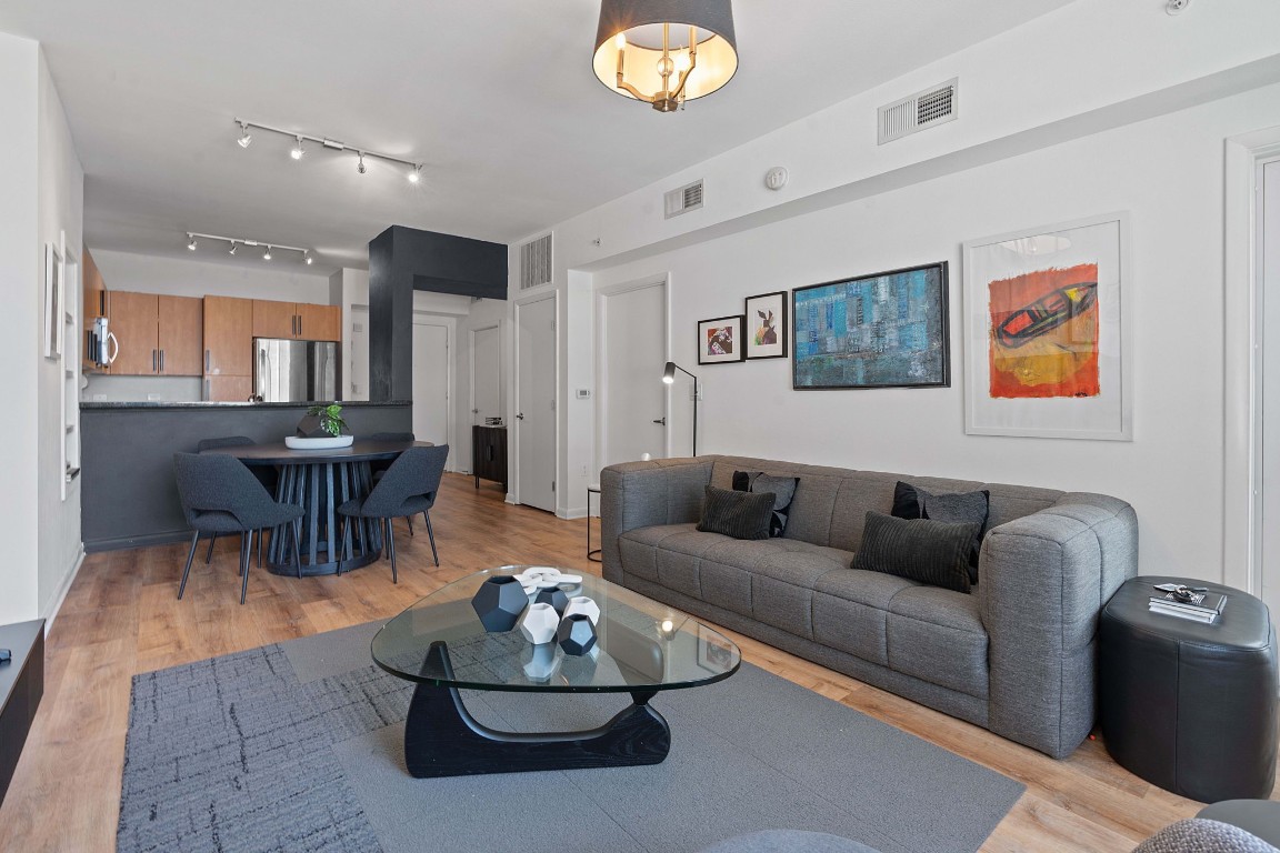 a living room with furniture a rug and kitchen view