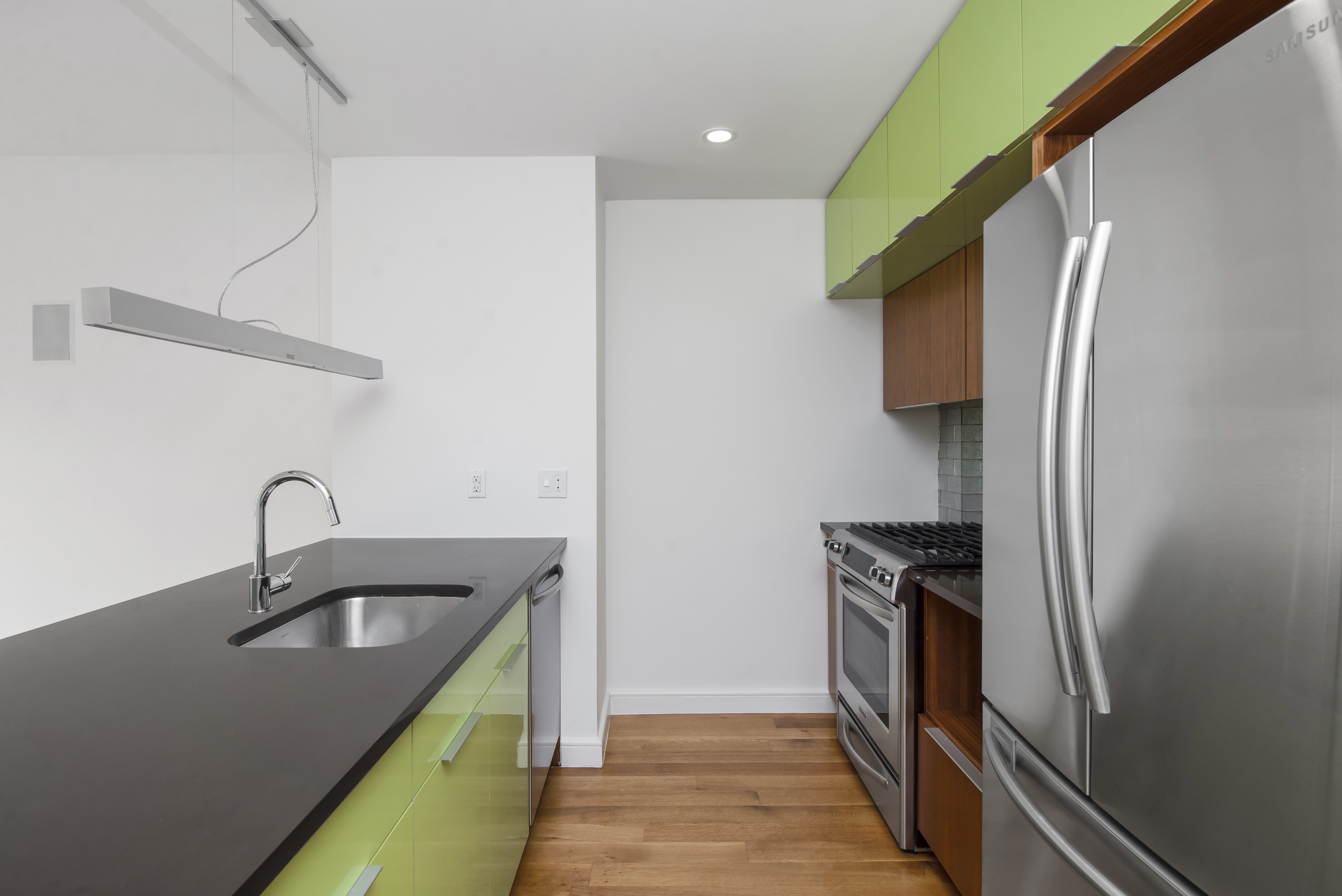 a kitchen with stainless steel appliances a sink and a refrigerator