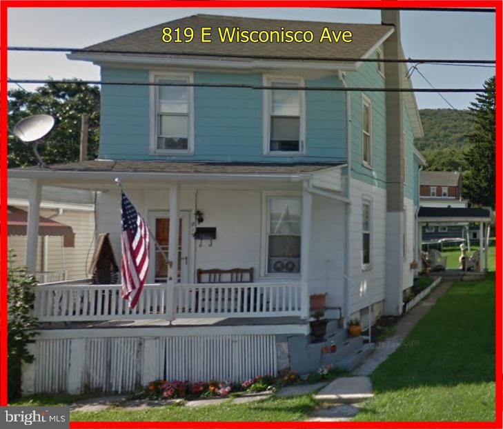 a view of a house with a small yard and wooden fence