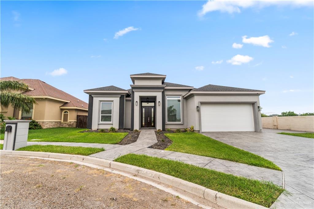 a front view of a house with a yard and garage