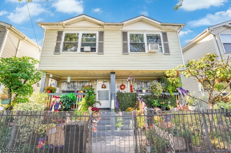 a front view of a house with a yard and potted plants