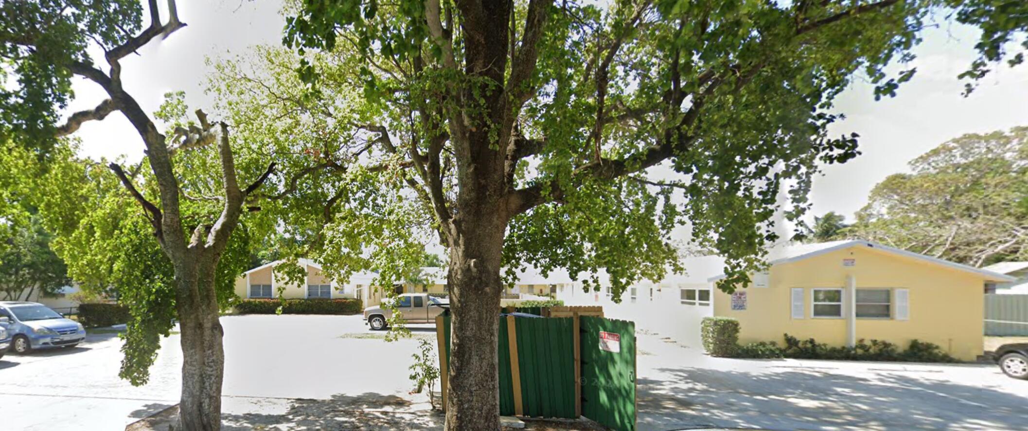 a front view of a house with a yard and tree s