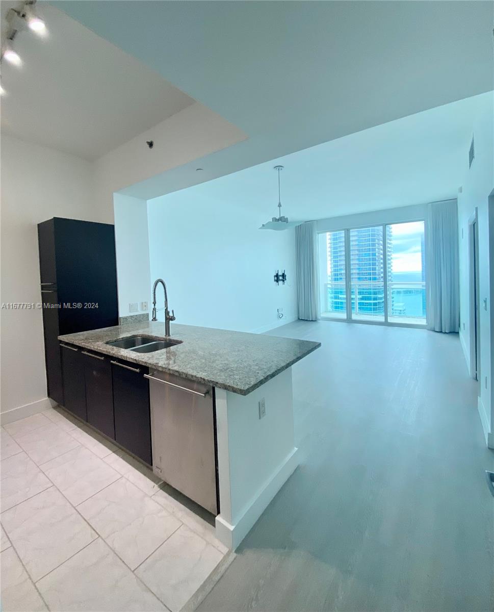 a kitchen with stainless steel appliances granite countertop a sink and a stove