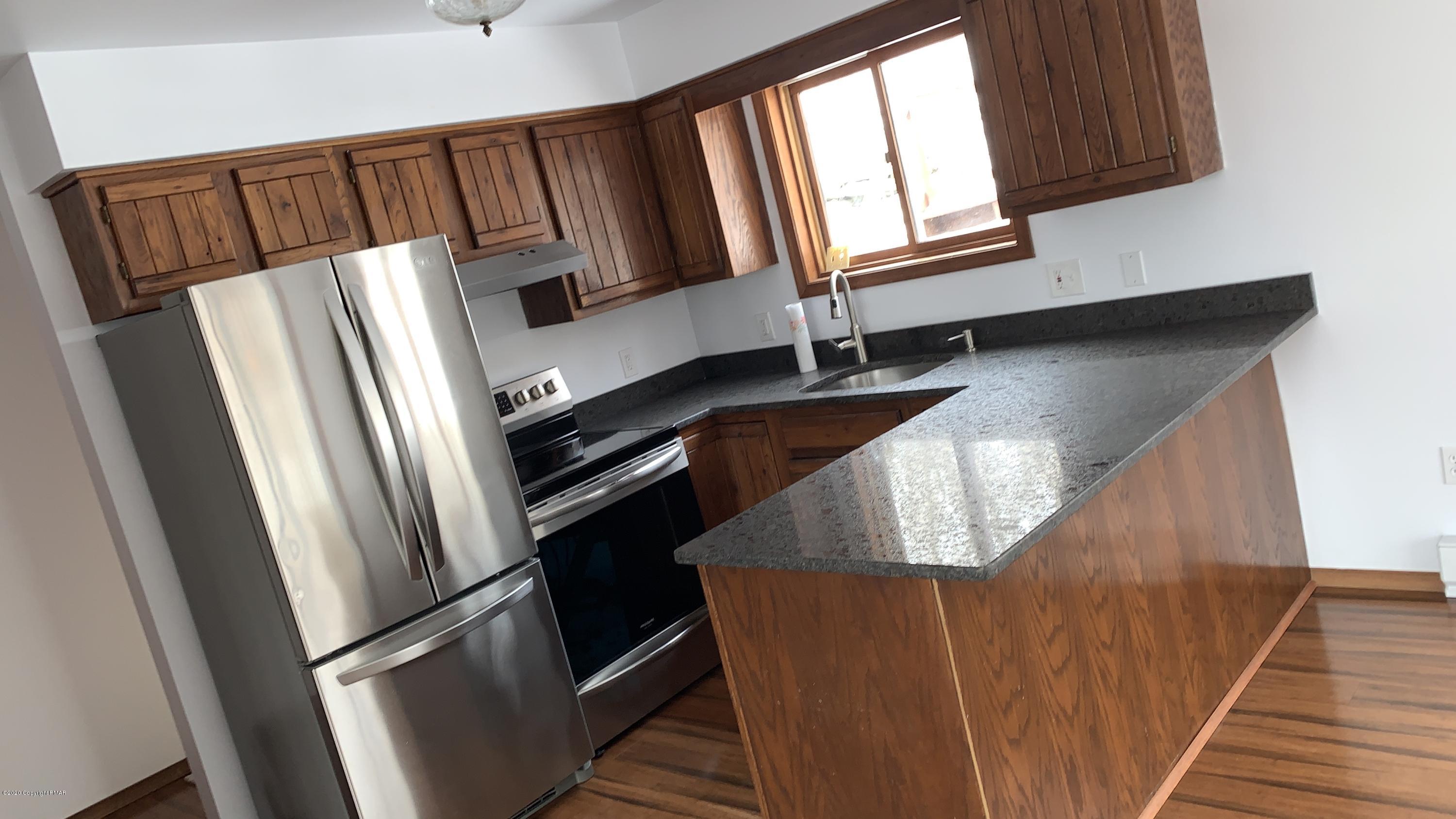 a kitchen with windows and refrigerator