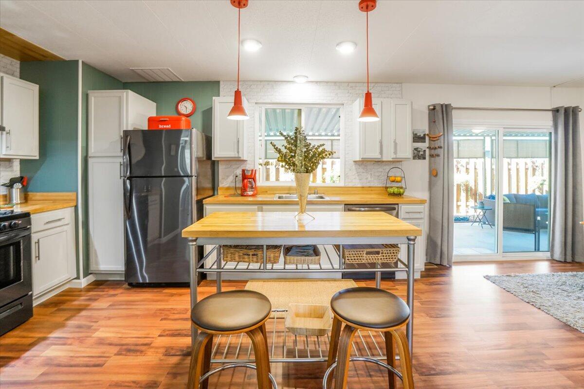 a kitchen with refrigerator a stove and chairs