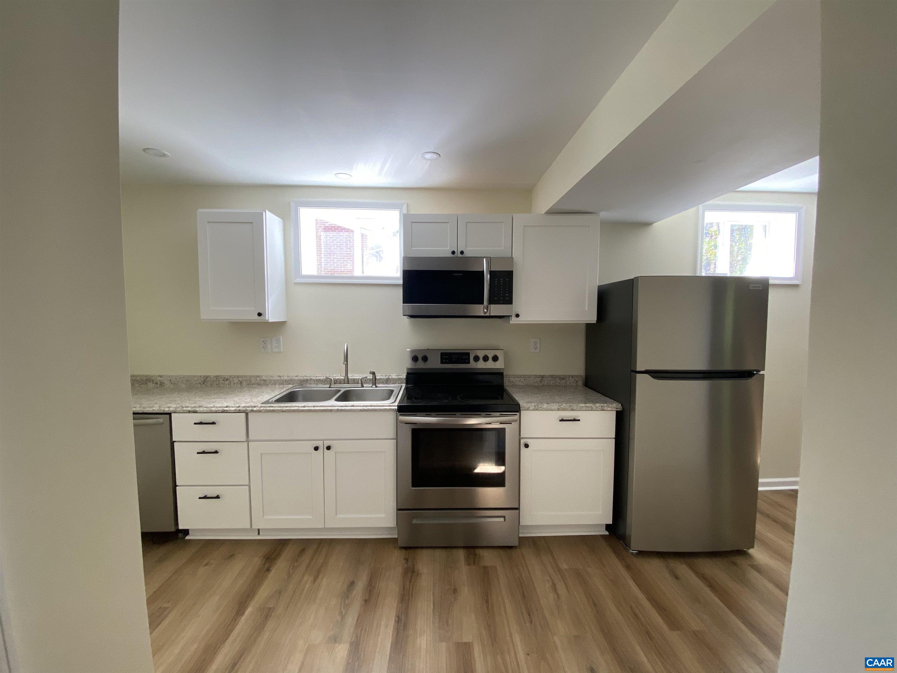 a kitchen with a stove a refrigerator and a microwave