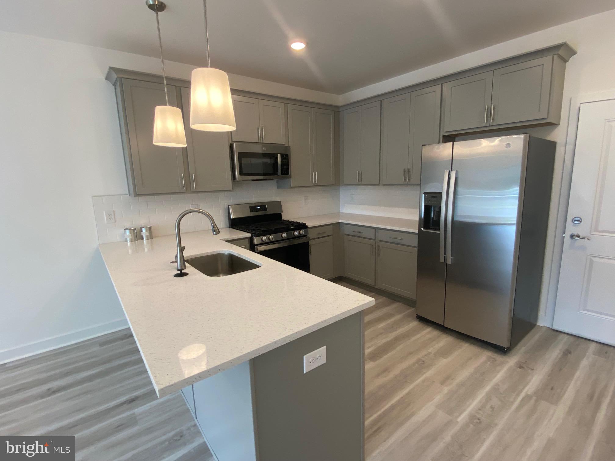 a kitchen with stainless steel appliances a refrigerator sink and microwave