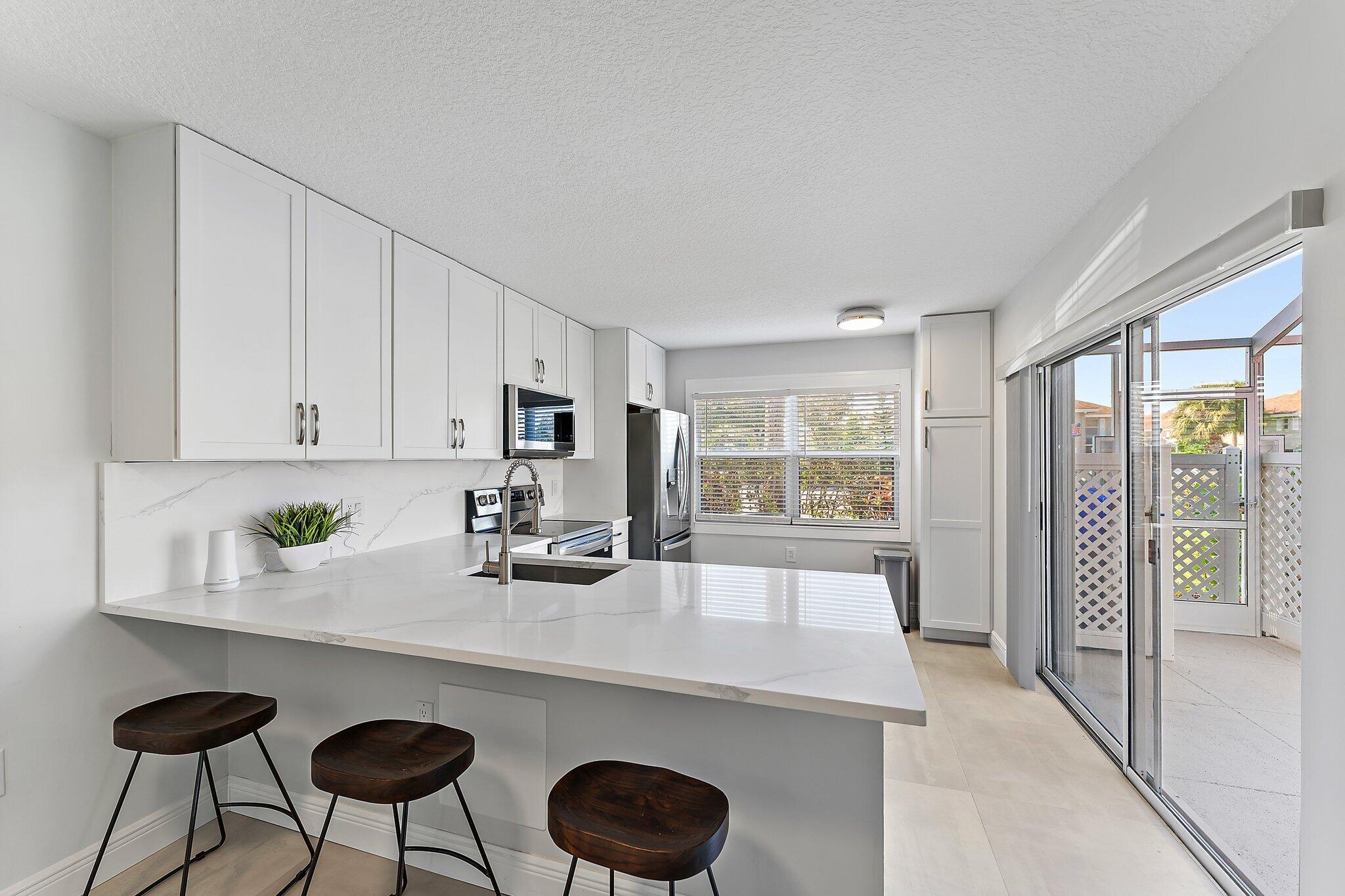 a kitchen with granite countertop a sink and white cabinets