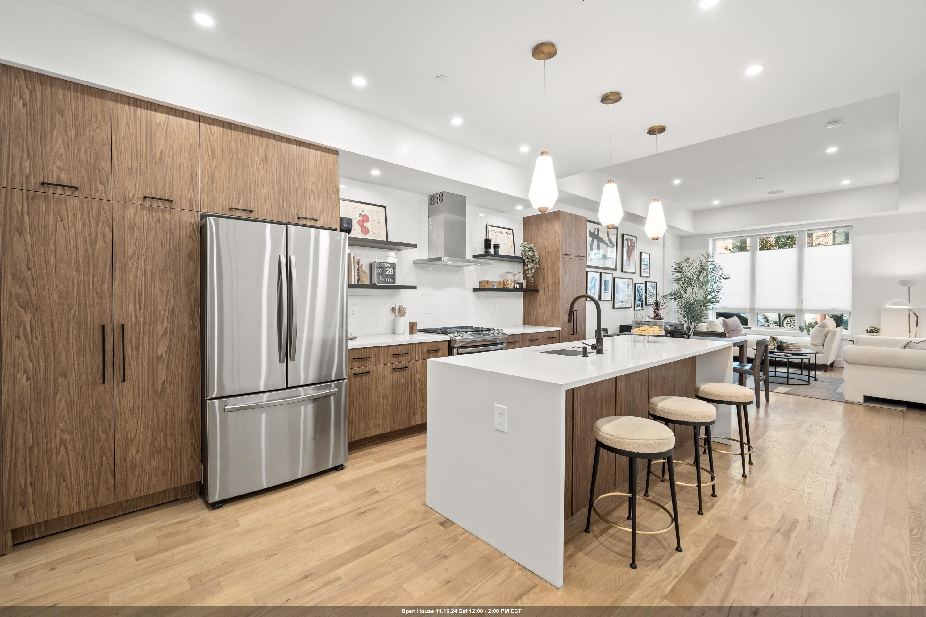 a kitchen with stainless steel appliances granite countertop a refrigerator and a stove top oven