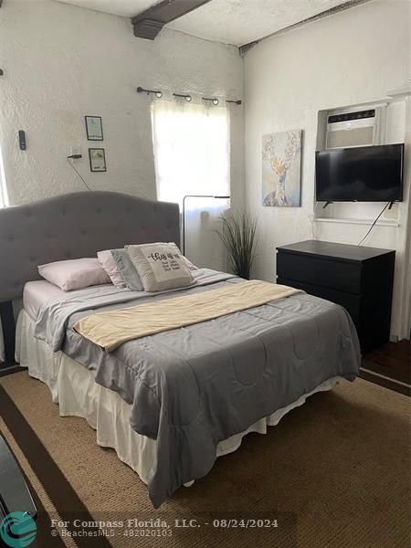 a bedroom with a bed and a flat screen tv