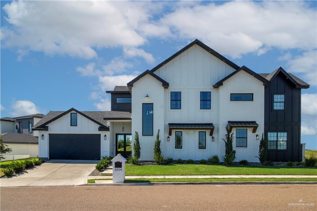 Modern farmhouse style home with a garage and a front yard