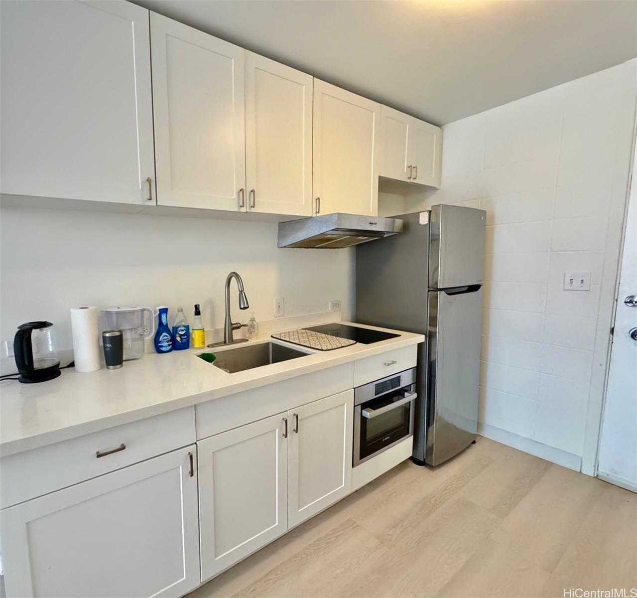 a kitchen with stainless steel appliances granite countertop white cabinets and a sink