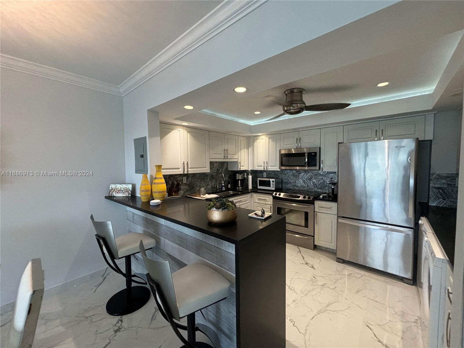 a kitchen with kitchen island a counter top space cabinets and stainless steel appliances