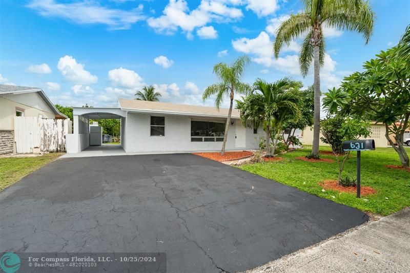 a view of a house with a yard and palm trees