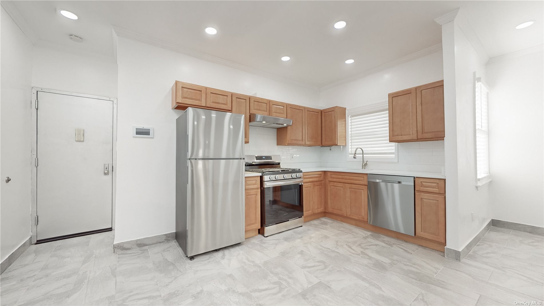 a kitchen with stainless steel appliances granite countertop a refrigerator sink and stove